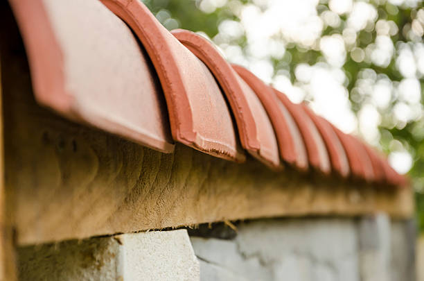 Close-up van rode dakpannen op de rand van een muur.